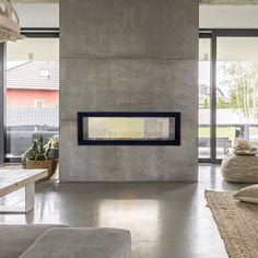 a living room with concrete walls and a fire place