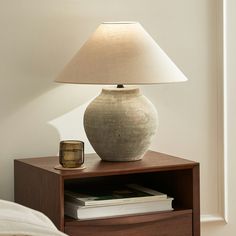 a lamp is sitting on top of a night stand