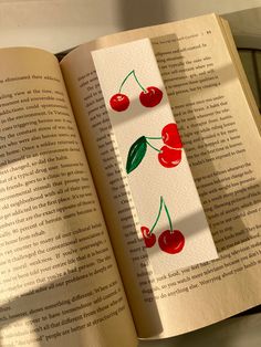 an open book with cherries on it and the pages have been cut out to look like cherry's