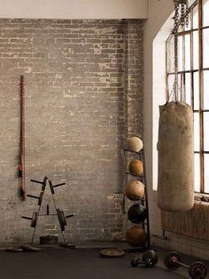 a room with a brick wall and several objects on the floor in front of it