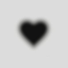 a black heart shaped object on a gray background with the shadow of a person's head