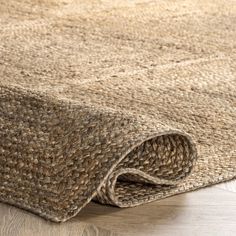 an area rug on the floor that is made out of jute and has been rolled up