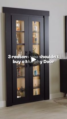 a black cabinet with three glass doors and shelves in the middle, next to a tv