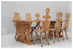 a table and chairs made out of wood with carvings on the back, sitting side by side