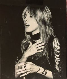 black and white photograph of a woman holding a glass in her hand with both hands