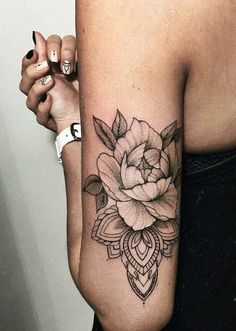 a woman's arm with a rose tattoo on the left side of her arm