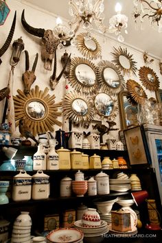 a room filled with lots of different types of clocks and other things on the wall