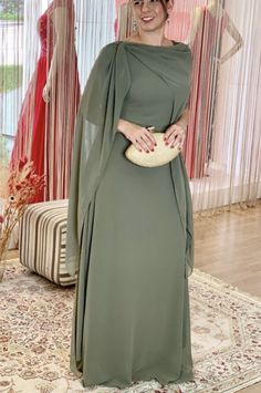 a woman in a green dress standing on a rug