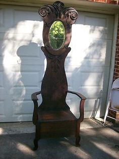 an old chair sitting in front of a garage door with a mirror on it's back