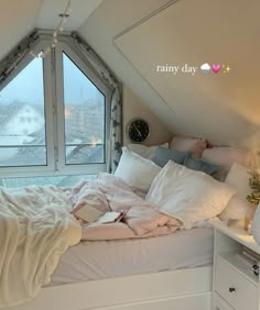 an unmade bed with white sheets and pillows in front of a large window that looks out onto the snow covered mountains