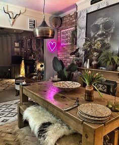 a wooden table sitting inside of a living room next to a fire place and potted plants