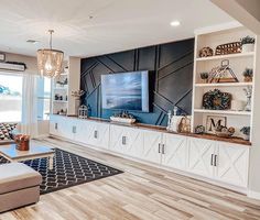 a living room filled with furniture and a flat screen tv on top of a wooden entertainment center