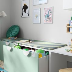 a child's room with a bed, desk and toy bins on the floor