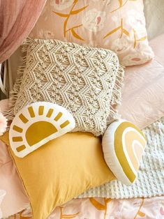 a bed with pink and yellow pillows on it's sides, along with other decorative items