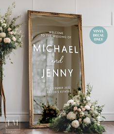 a mirror and flowers on the floor in front of a sign that says welcome to the wedding of michael and jenny