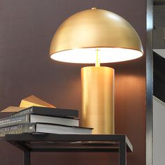 a lamp sitting on top of a table next to books