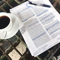 a cup of coffee and some papers on a table