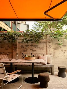 an outdoor table and chairs are set up on the patio with orange awnings