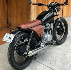 a black motorcycle parked in front of a wooden building