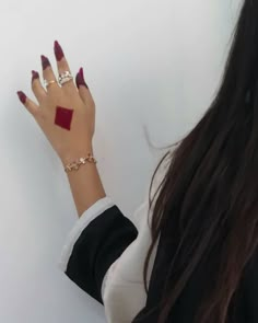 a woman's hand with red manicures and ring on her left wrist