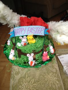 an easter basket is decorated with fake grass and stuffed animals