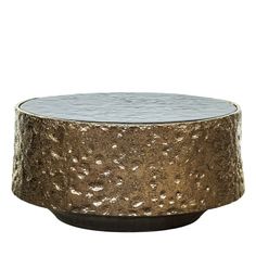 a round metal table with gold and silver foil on the top, against a white background