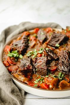 a bowl filled with meat and vegetables on top of a table