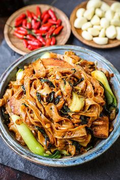 a bowl filled with noodles and vegetables on top of a table