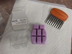 a couple of pieces of wax sitting on top of a towel next to a comb