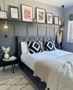 a bedroom with gray walls and pictures on the wall