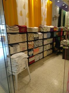 there is a display in the store with many folded shirts on it's racks