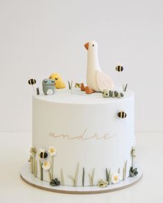 a white cake decorated with animals and bees