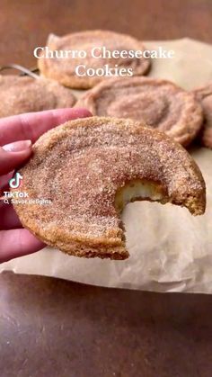 a person holding up a sugar covered doughnut