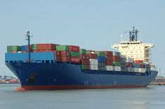 a large cargo ship with lots of containers on it's side in the water