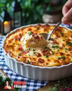 a person scooping cheese from a casserole dish with a spoon in it