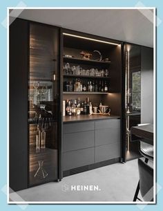 an image of a modern bar in the middle of a room with black cabinets and glass doors