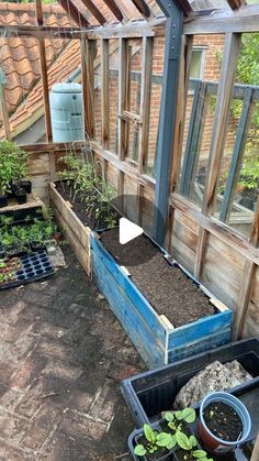 an outdoor greenhouse with several plants in it