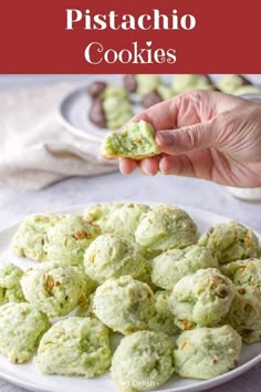 a person is picking up some kind of green dessert from a plate on the table