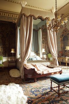 an ornate bedroom with four poster bed and chandelier