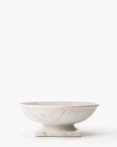 a white bowl sitting on top of a marble base