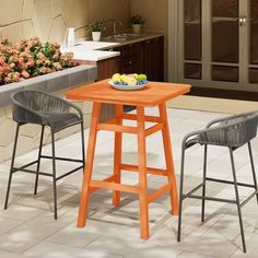 an outdoor table with two chairs and a bowl of fruit on the table next to it