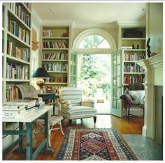 a living room filled with lots of books and furniture