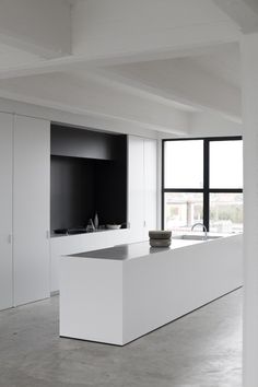 an empty room with a bowl on the counter and a large window in the background