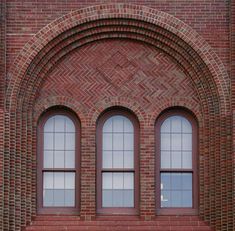 a red brick building with three arched windows