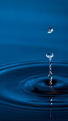 a water droplet is seen in the middle of a body of water with ripples