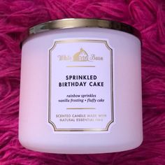 a pink candle sitting on top of a purple blanket with the words sprinkled birthday cake