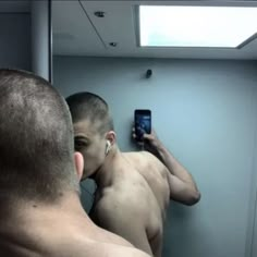 a man taking a selfie in front of a bathroom mirror with his cell phone