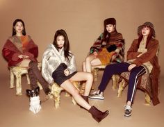 four young women sitting on chairs in winter clothes