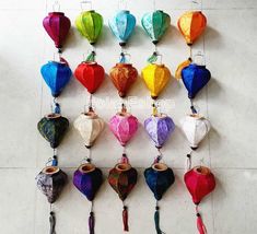 many different colored paper lanterns hanging on the wall