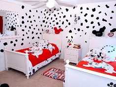 a bedroom decorated in red and white with mickey mouse wallpaper